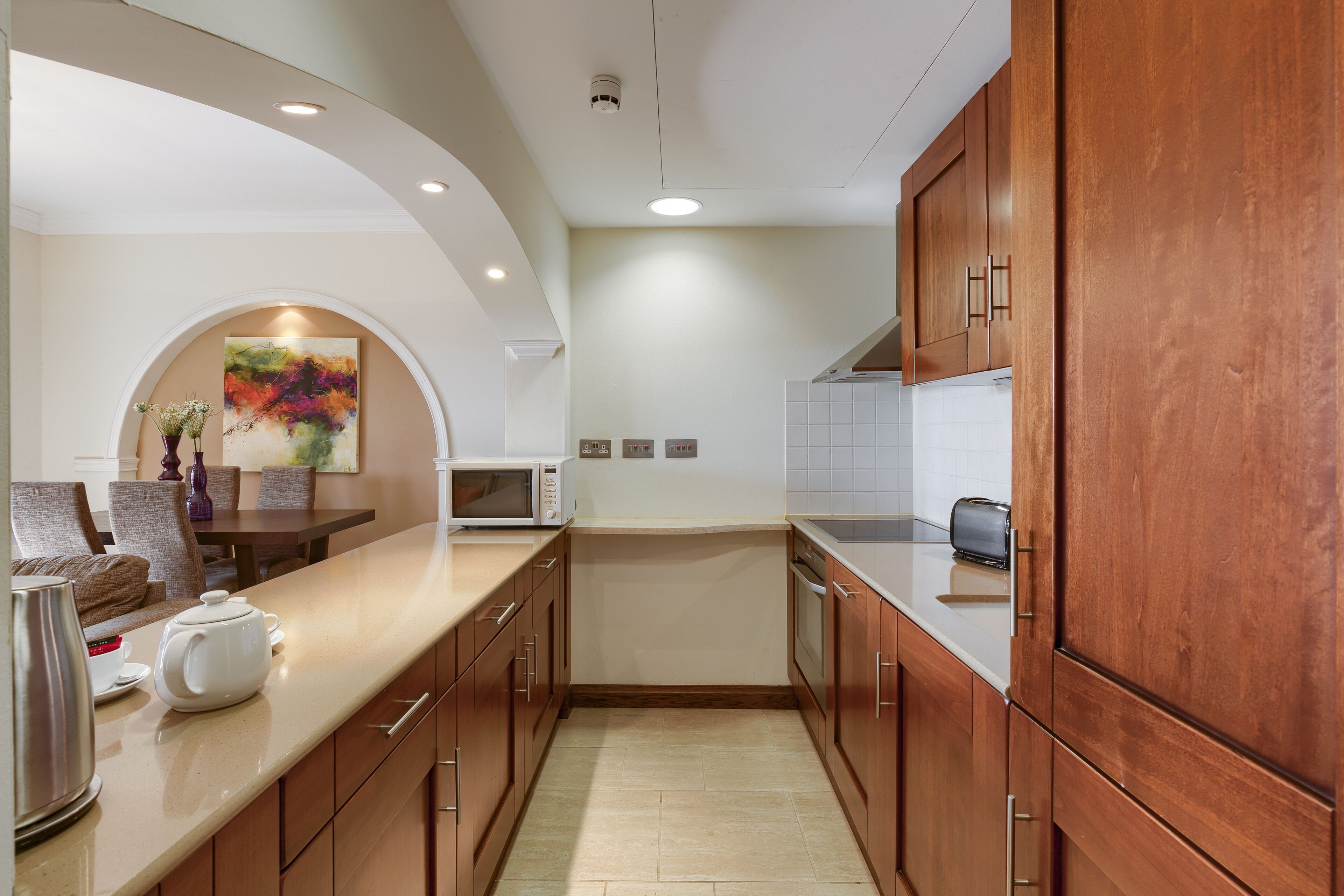 A modern kitchen with wooden cabinets, a microwave, and a toaster.