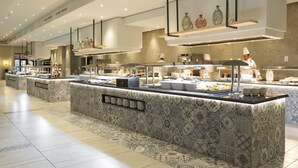 A modern buffet area with patterned tile flooring and a variety of food stations.