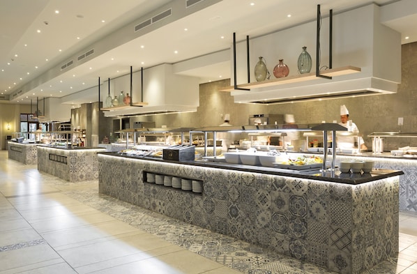 A modern buffet area with patterned tile flooring and a variety of food stations.