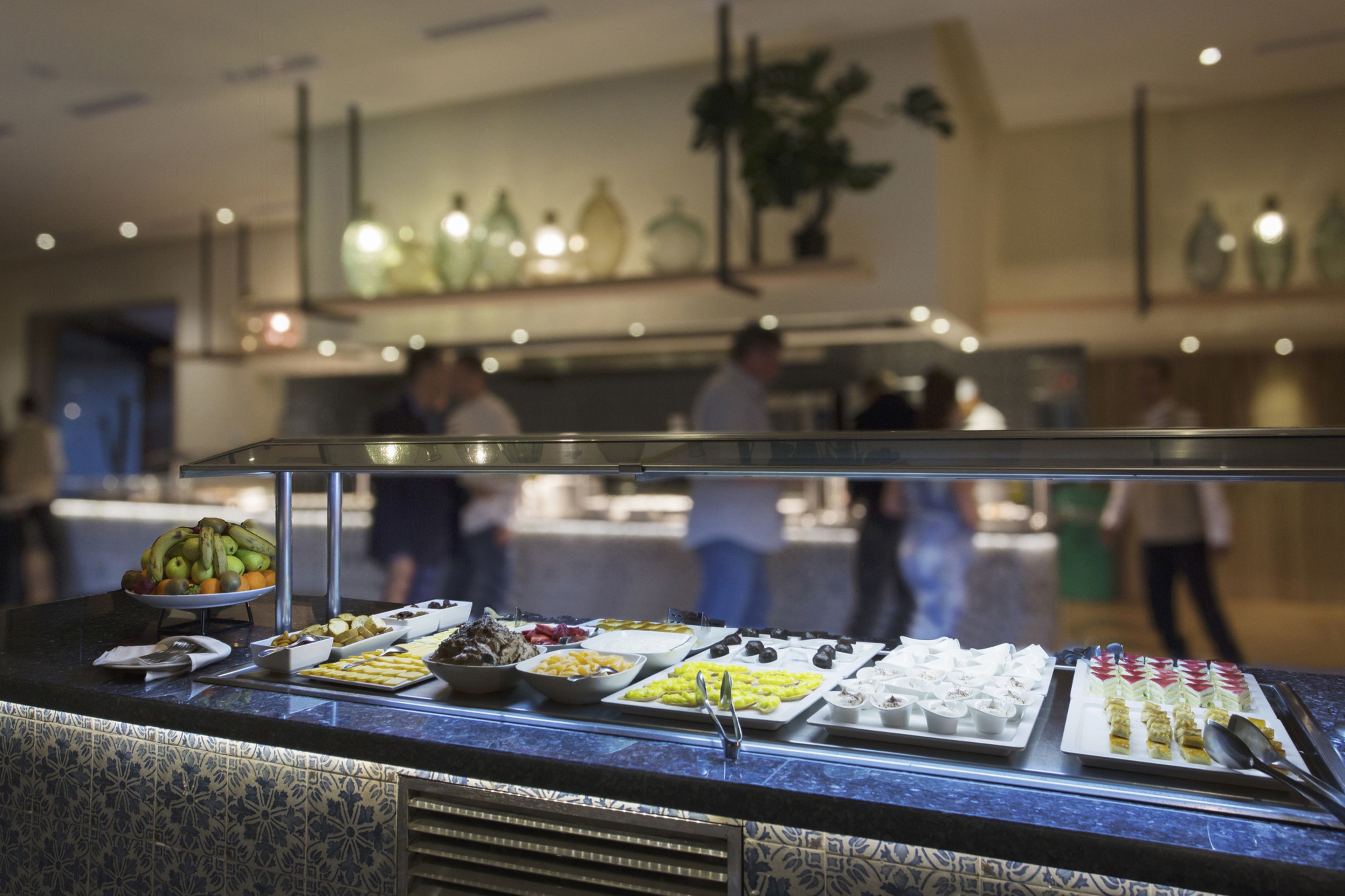 Un buffet proposant une variété de plats et un comptoir avec un mur arrière recouvert de carreaux.