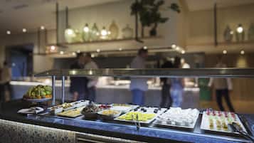 Un buffet proposant une variété de plats et un comptoir avec un mur arrière recouvert de carreaux.