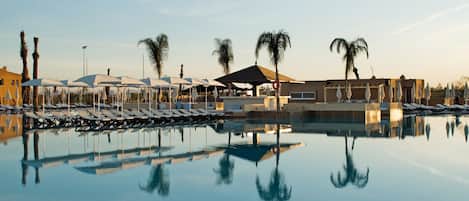 Piscine intérieure, piscine extérieure, parasols, chaises longues