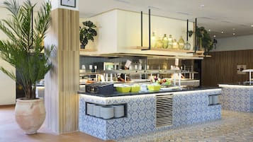 Une cuisine moderne dotée d’un îlot central, d’appareils électroménagers intégrés et d’un revêtement mural décoratif.