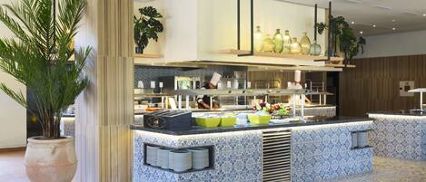 Une cuisine moderne dotée d’un îlot central, d’appareils électroménagers intégrés et d’un revêtement mural décoratif.