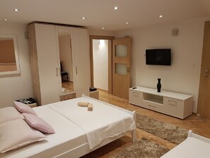 A bedroom with a bed, a wardrobe, a TV, and a small table. - Guest House Vlado (Split)