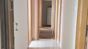 A corridor with tiled flooring, wooden doors, and a visible refrigerator in the background. - Guest House Vlado (Split)