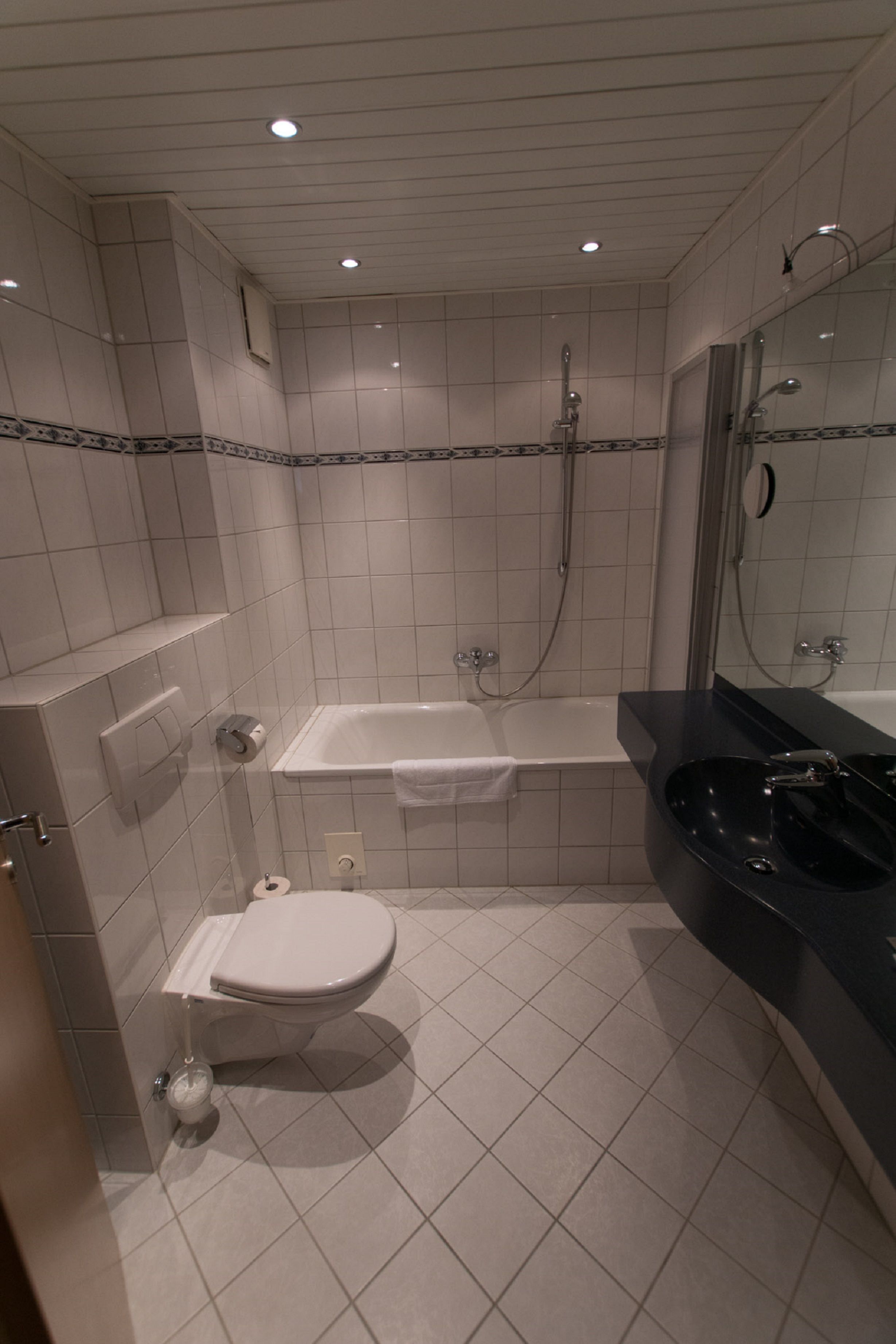 A bathroom with a toilet, a bathtub, and a sink.