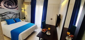 Una habitación de hotel con cama, una mesa con desayuno y un armario.