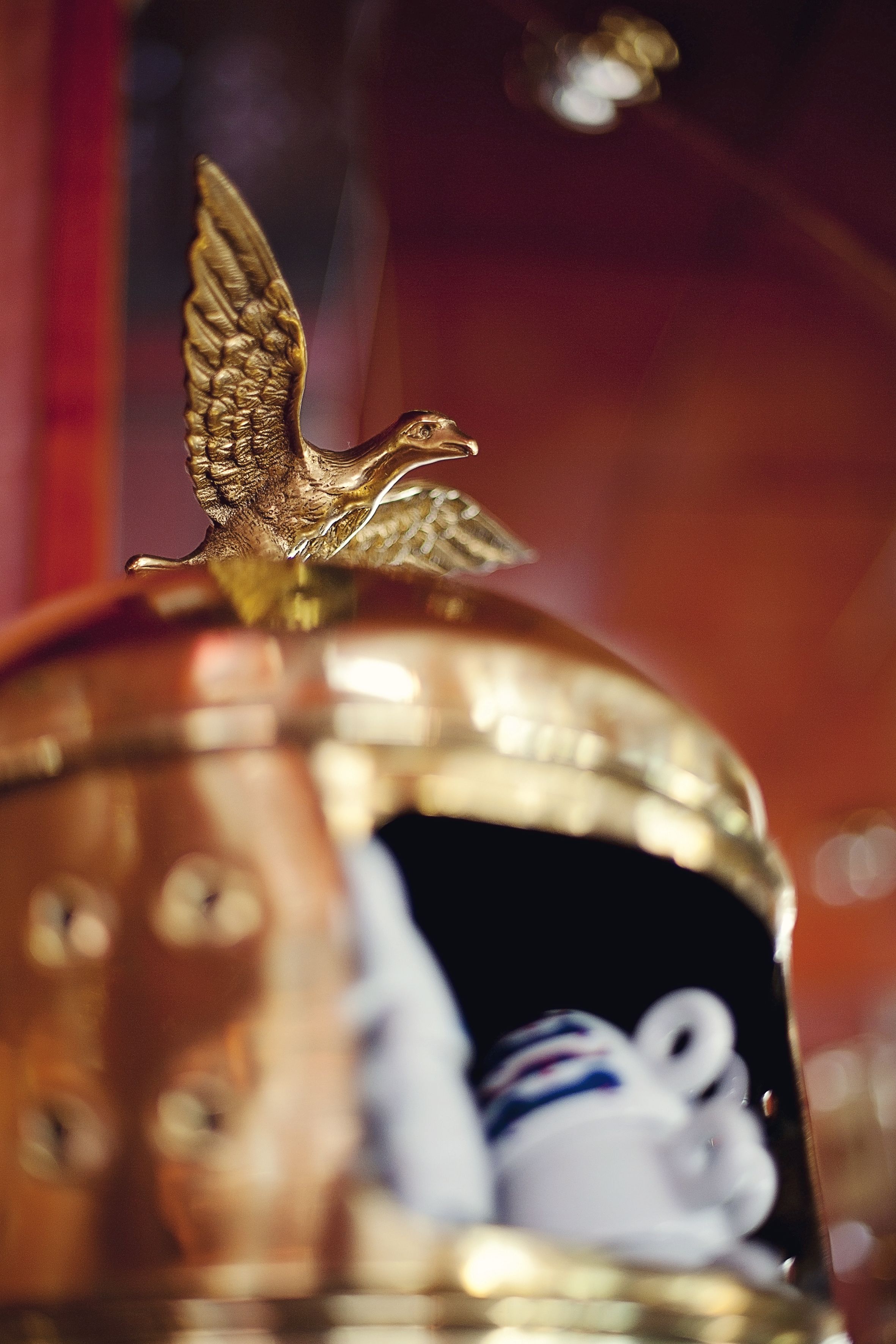 A brass bell with a golden angel figurine on top.