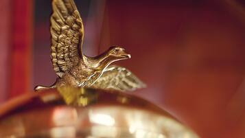 Una campana de bronce con una figurita de ángel dorado en la parte superior.