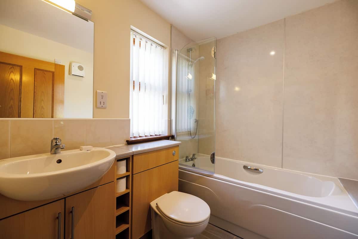 A modern bathroom with a sink, toilet, and bathtub.
