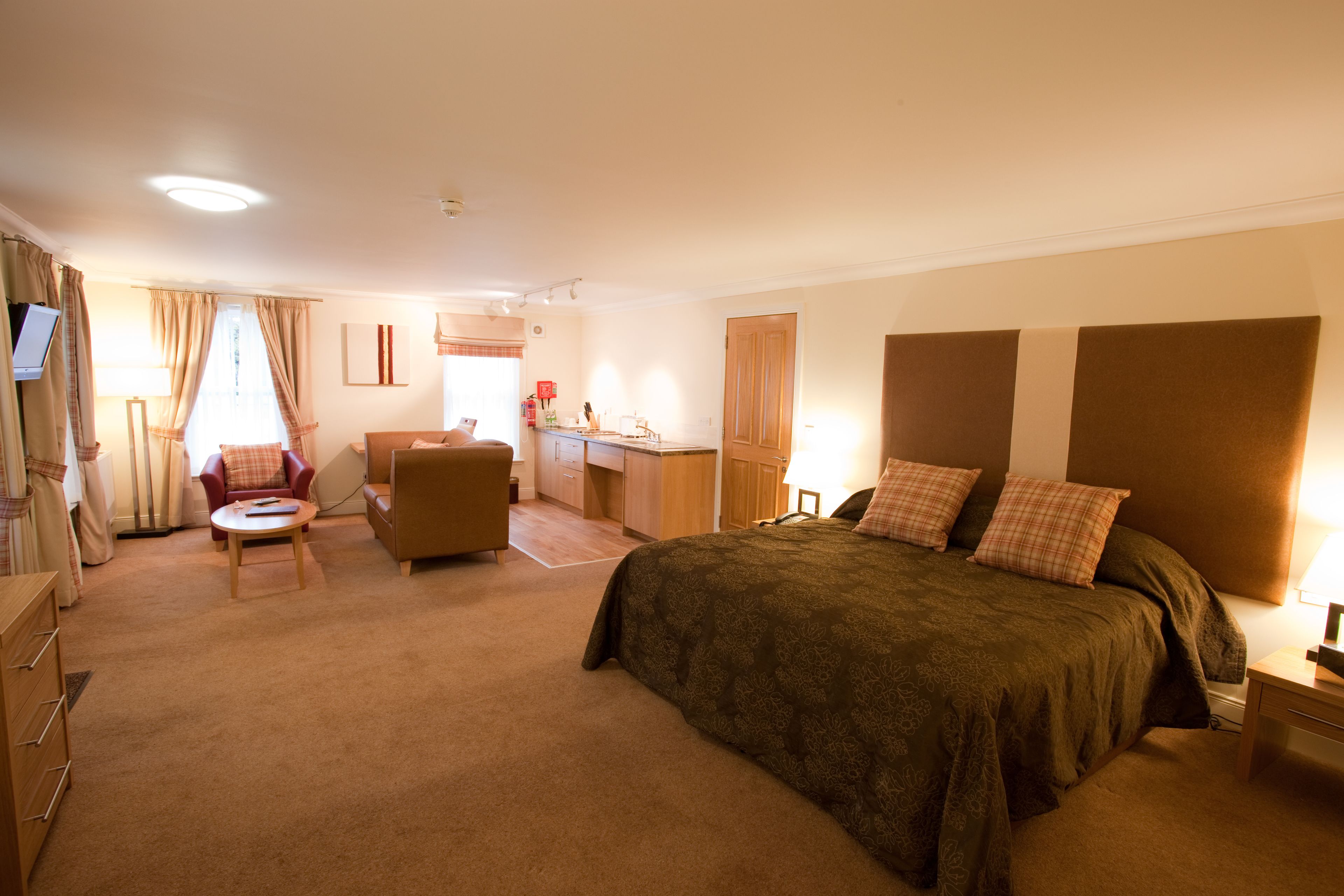 Ein Hotelzimmer mit Bett, Schreibtisch, Stuhl, Fernseher und Bad.