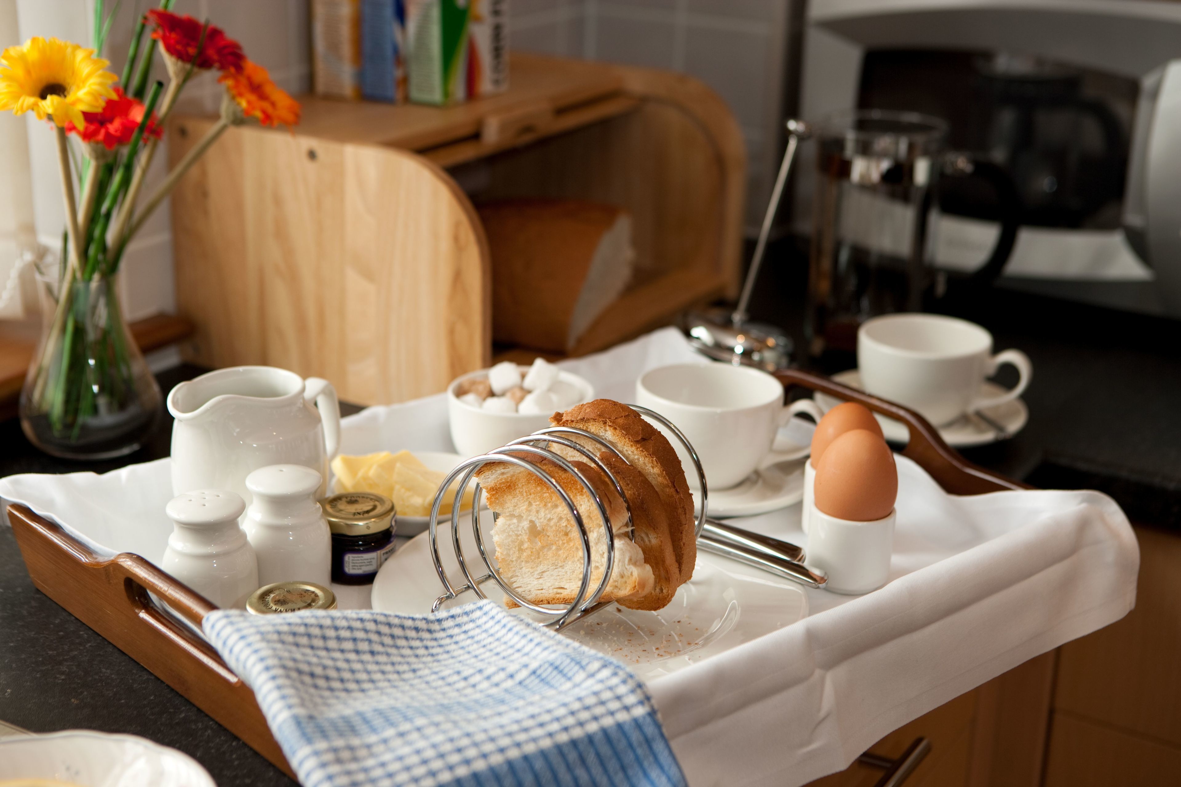 A breakfast tray with bread, eggs, and condiments on a kitchen counter.