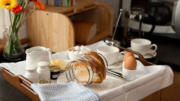 Ein Frühstücksbrett mit Brot, Eiern und Beilagen auf einer Küchenarbeitsfläche.
