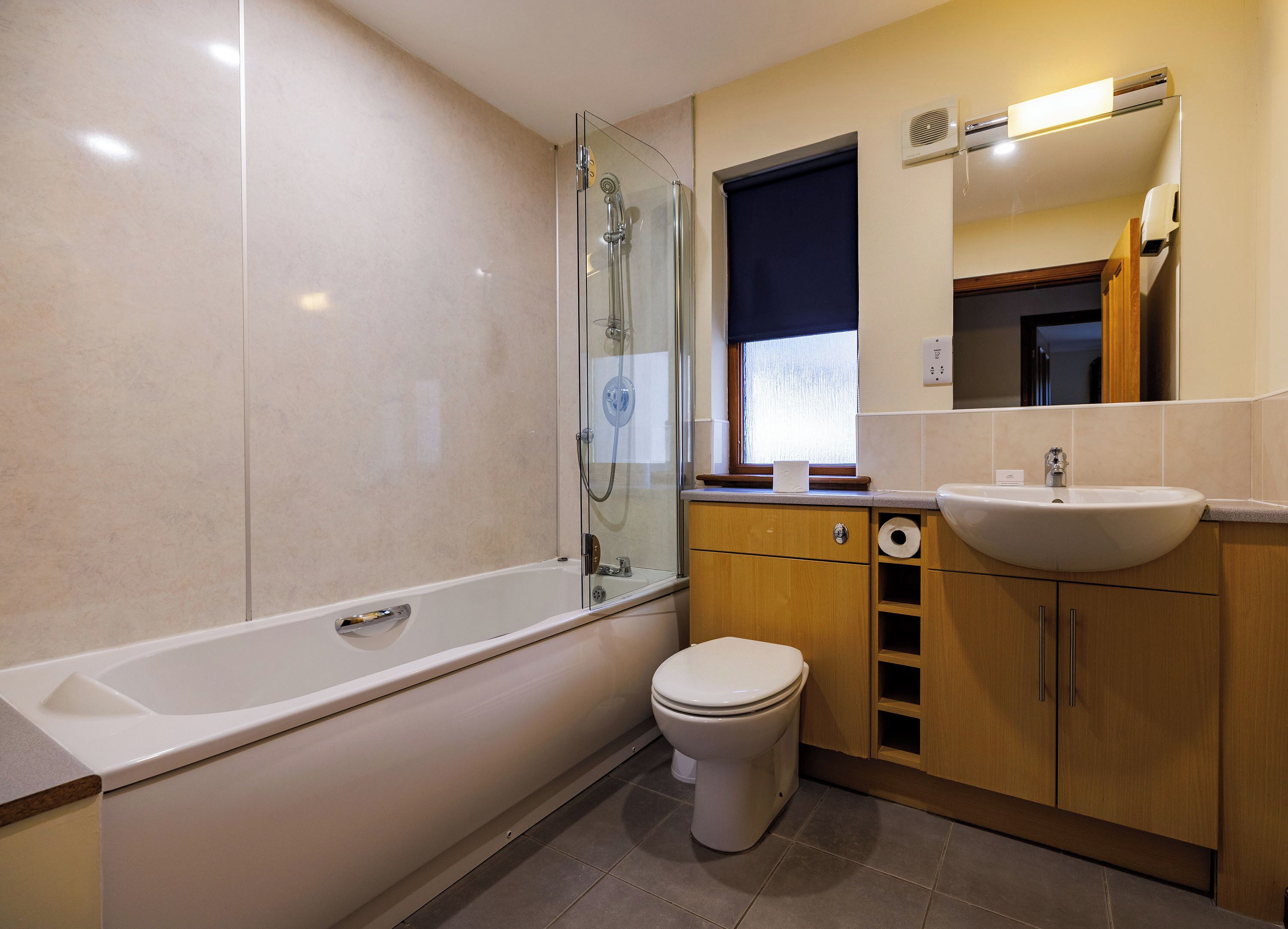 Une salle de bain moderne avec une douche à parois de verre, des toilettes et un lavabo.