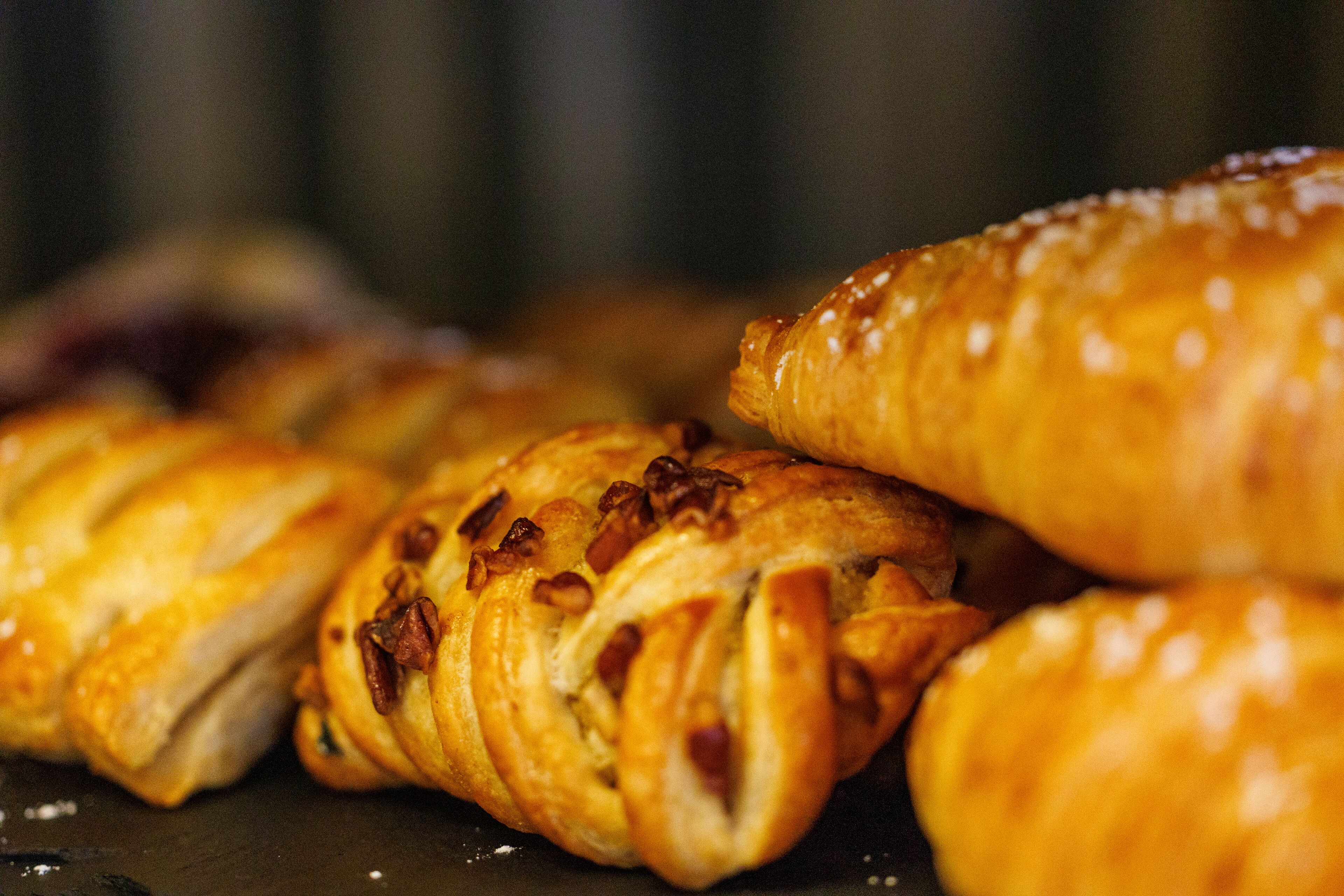 Variedad de pasteles, incluyendo croissants y otras preparaciones horneadas, expuestos sobre una superficie.