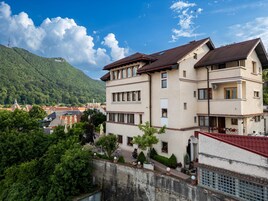 Un edificio de varios pisos con un estilo arquitectónico tradicional, que cuenta con un balcón y un pequeño jardín.