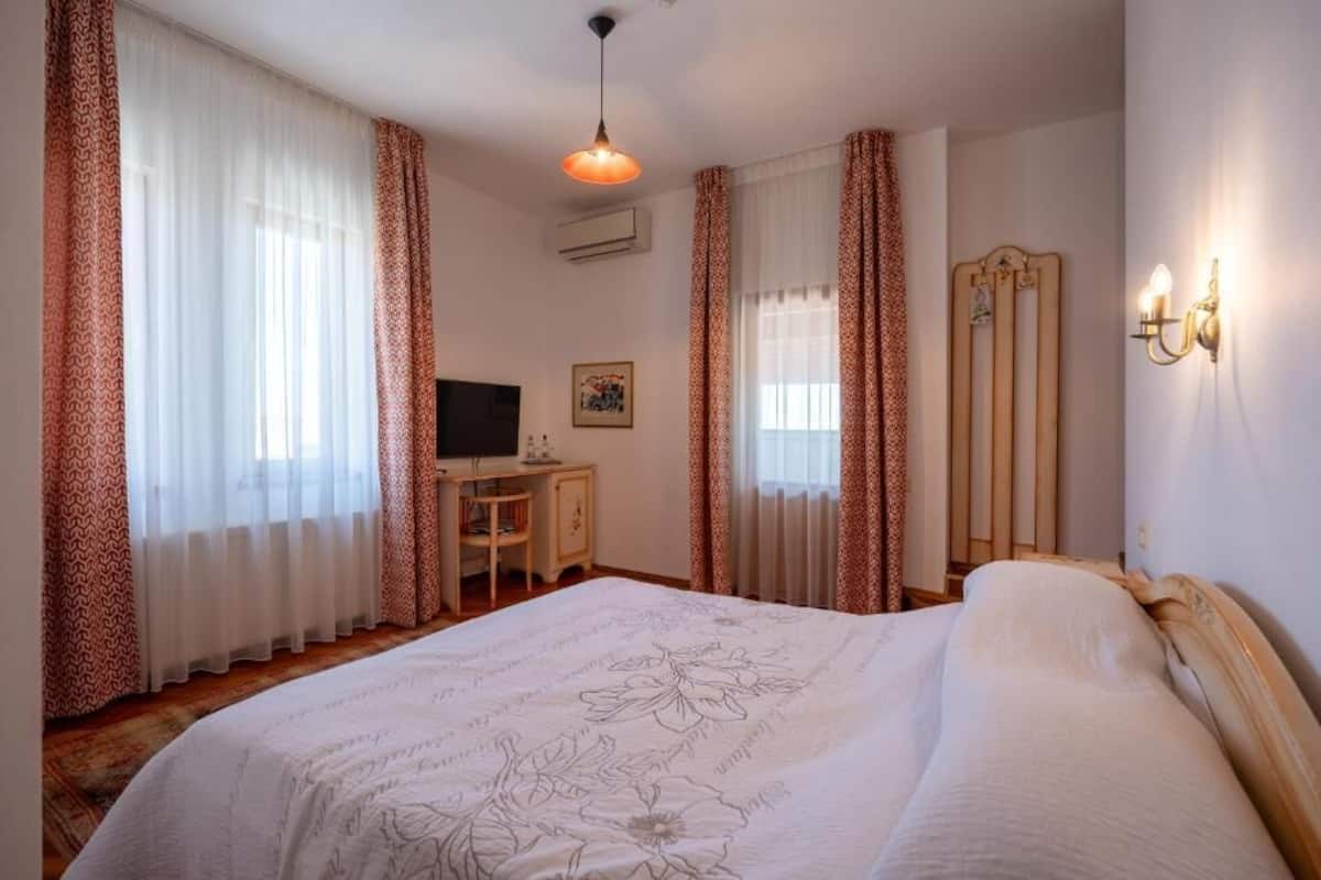 Ein Schlafzimmer mit einem großen Bett, einem Schreibtisch mit Computer und einem Kleiderschrank.