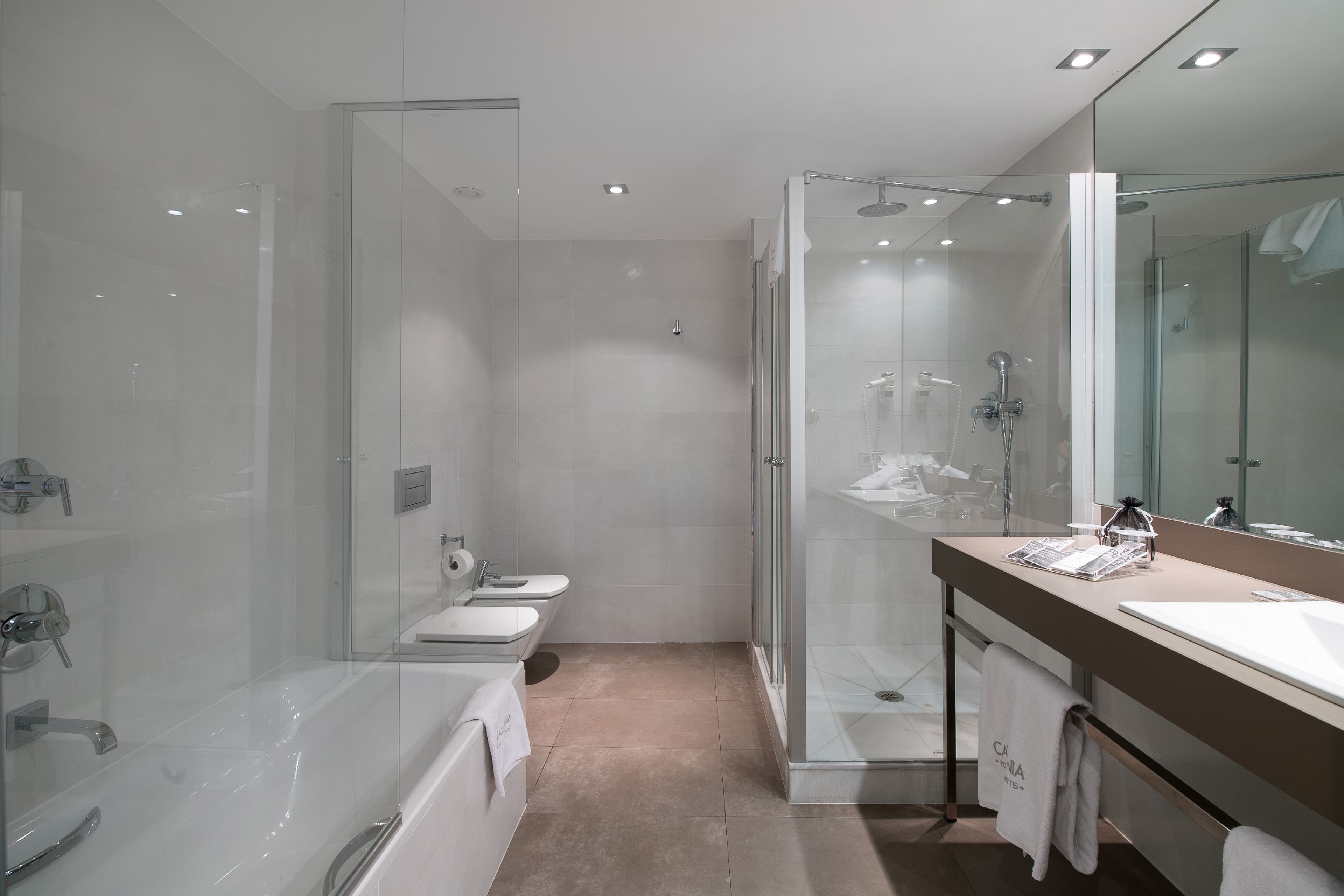 A modern bathroom with a glass-enclosed shower, a bathtub, and a vanity with a mirror.