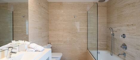 A modern bathroom with a glass-enclosed shower, a white sink, and a toilet.