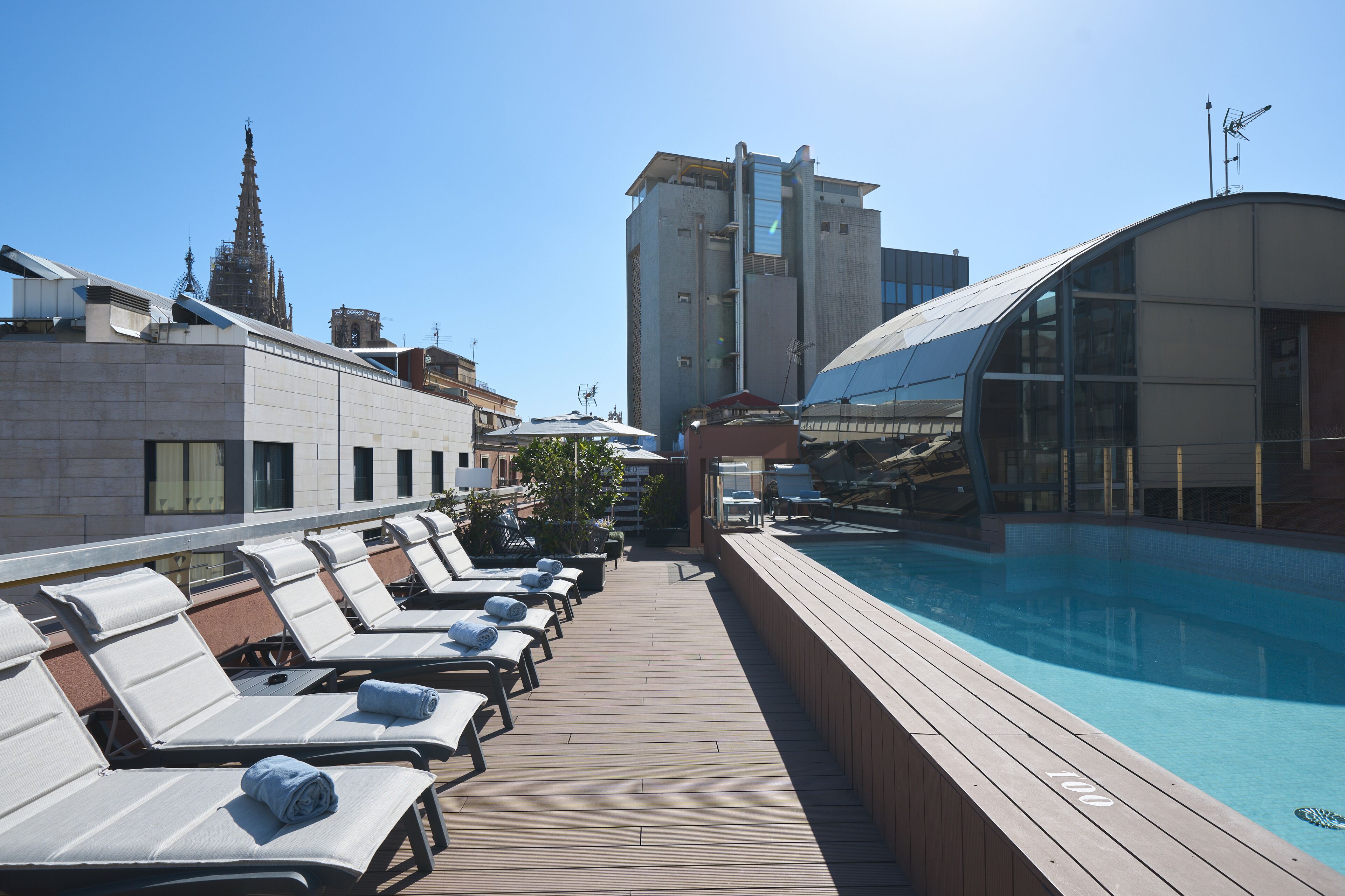 Een buitenzwembad, ligstoelen bij het zwembad