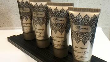 Four bottles of Bijoux shampoo and shower gel on a black tray.