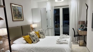 A modern hotel room with a large bed, bedside tables, a desk, and a chair. - Hotel La Reginella  (Capri)