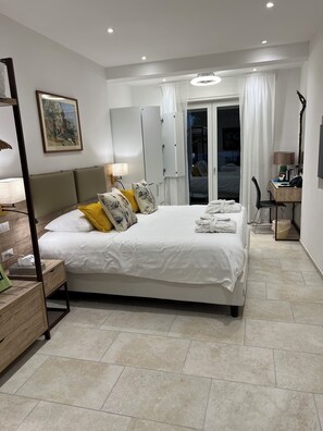 Deluxe studio suite, uitzicht op zee | Donsdekens, een minibar, een bureau, gratis wifi