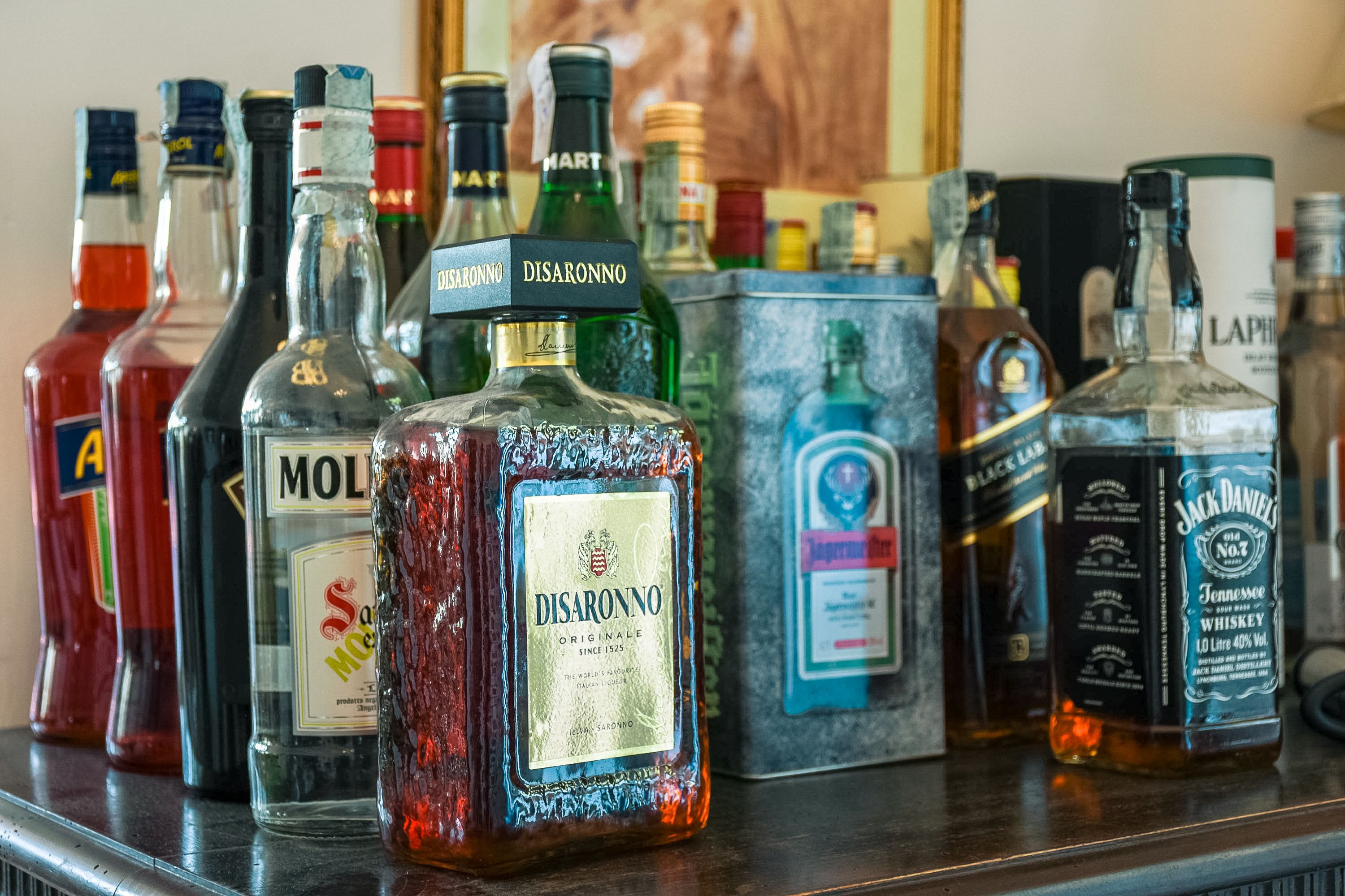 A variety of liquor bottles on a bar counter.