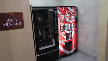 A vending machine with a Coca-Cola advertisement and a sign for 'Ice & Vending'.