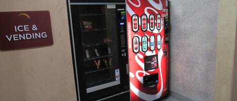 A vending machine with a Coca-Cola advertisement and a sign for 'Ice & Vending'.