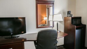 A hotel room with a flat-screen TV, a desk with a chair, a mirror, a lamp, a coffee maker, and a microwave. - Sleep Inn & Suites Highway 290/NW Freeway (Houston)