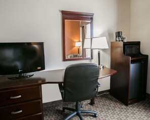 A hotel room with a flat-screen TV, a desk with a chair, a mirror, a lamp, a coffee maker, and a microwave. - Sleep Inn & Suites Highway 290/NW Freeway (Houston)