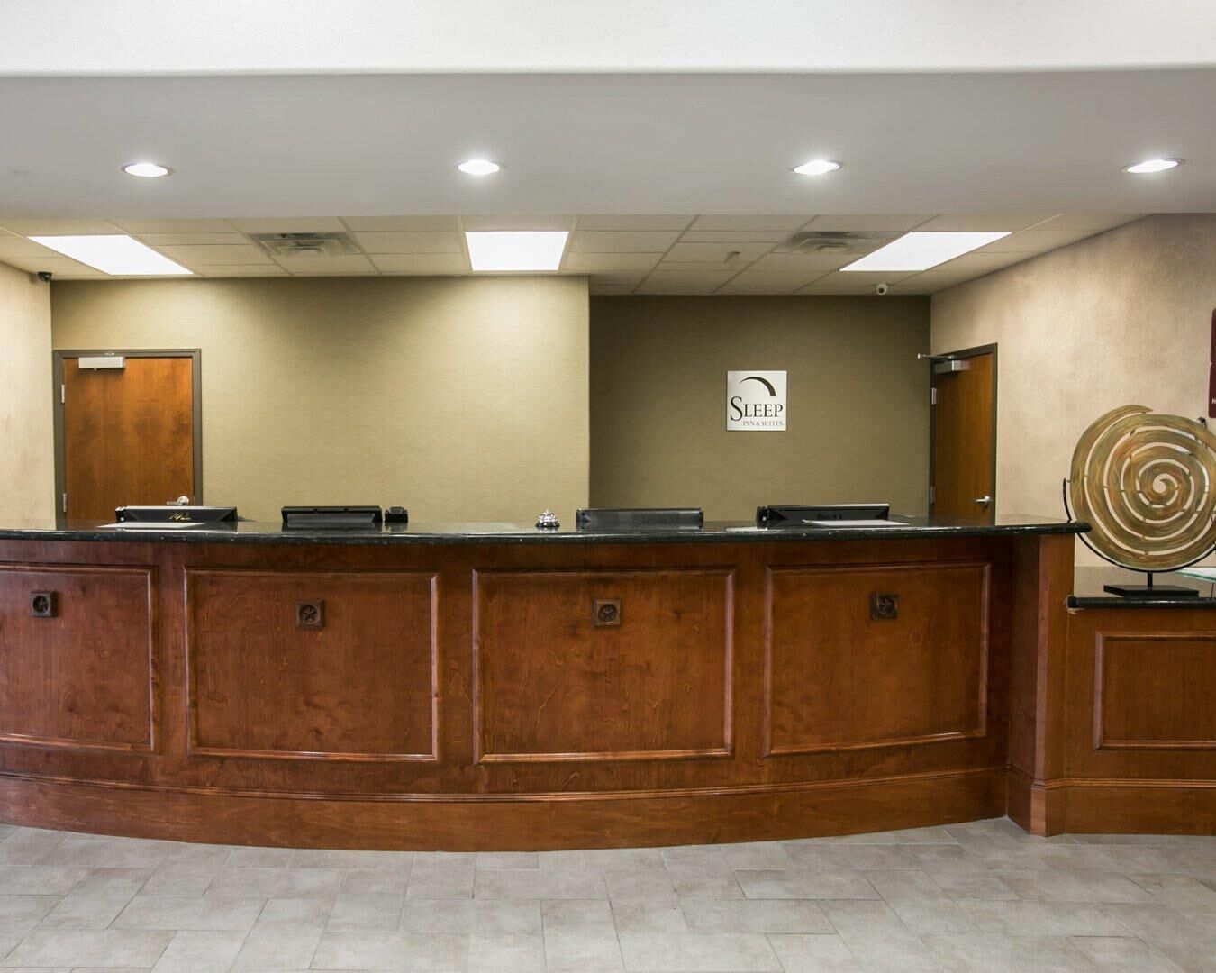 A reception desk with a 'Sleep Inspections' sign, a wooden counter, and a door in the background.