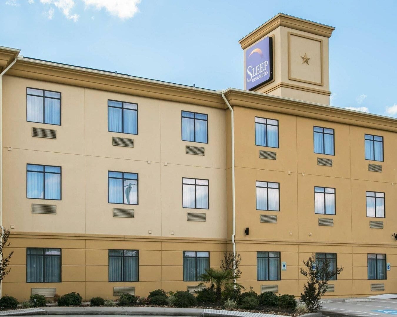 Un edificio de hotel de varios pisos con un letrero llamativo de Sleep Inn & Suites.