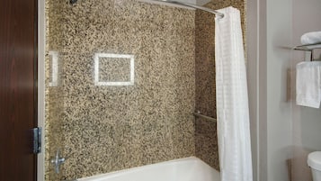 A bathroom with a bathtub, a shower curtain, and a towel rack.