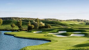 A golf course with a water body, sand bunkers, and a flagstick. - Kyriad Les Ulis (Les Ulis)