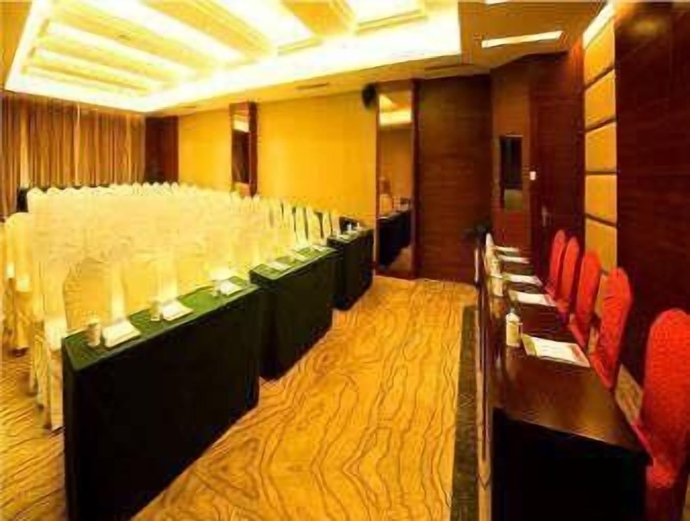 Un salón de conferencias con una larga mesa, sillas y un atril.
