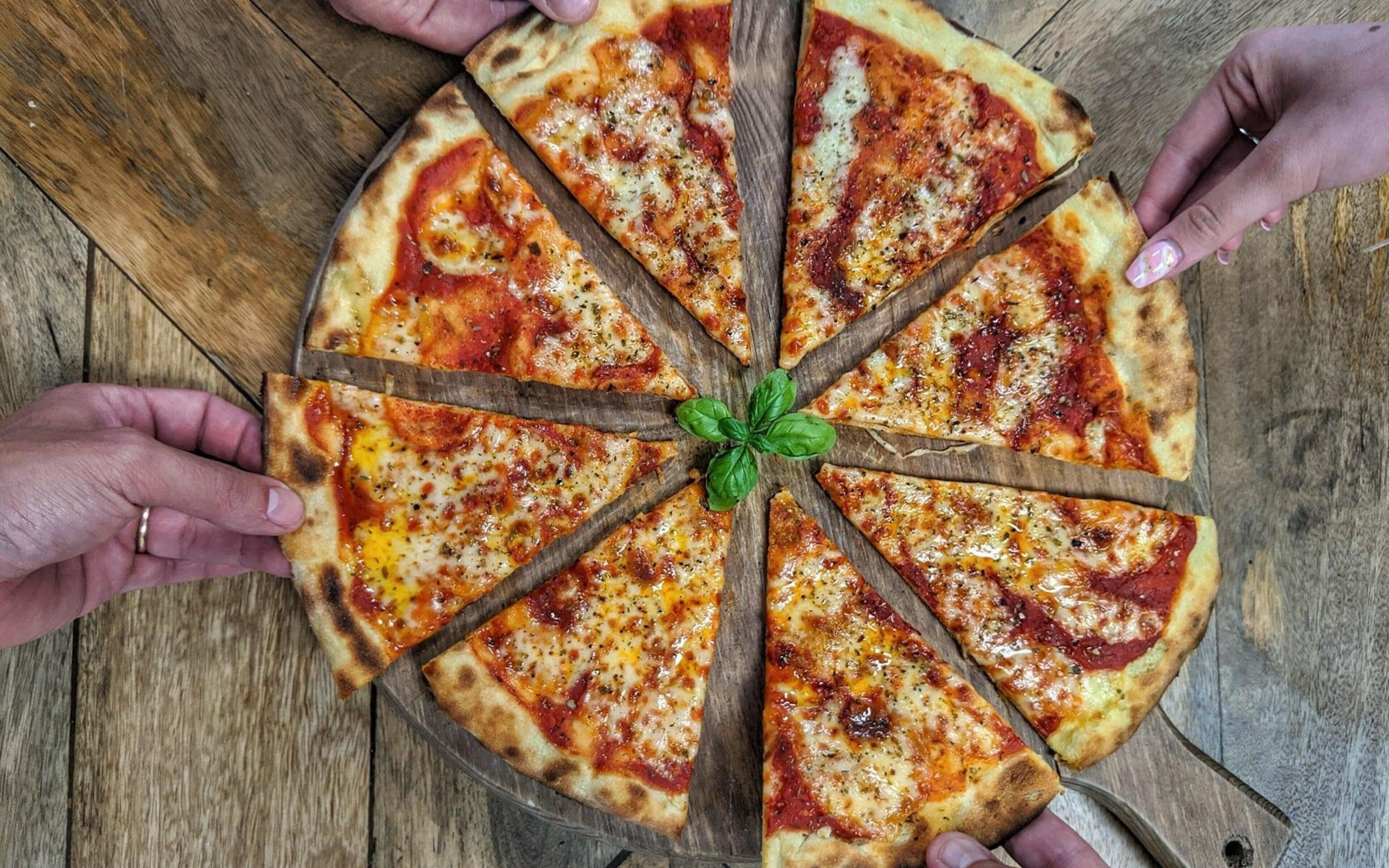 En pizza med otte skiver på en træplade.