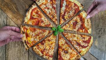A pizza with eight slices on a wooden board.