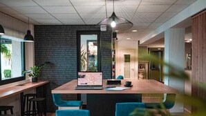 Een modern interieur met een eilandtafel in het midden, een bar en een accentmuur van baksteen.