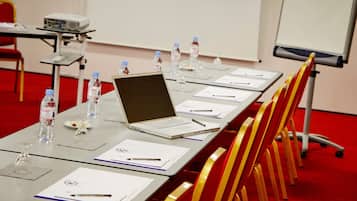 A conference room with a long table, laptops, water bottles, and chairs.
