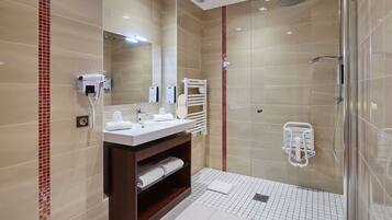 A modern bathroom with a glass-enclosed shower, a vanity with a mirror, and a heated towel rail.
