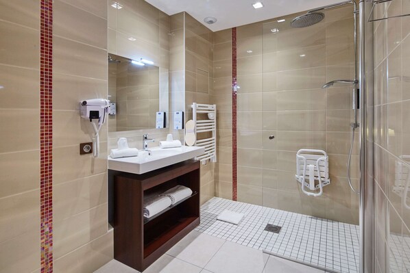 A modern bathroom with a glass-enclosed shower, a vanity with a mirror, and a heated towel rail.