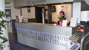 A reception desk with a sign reading "LA RÉCEPTION" and a welcome sign.