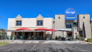 A hotel with a restaurant named "L'Atypik Restaurant" and a sign for "Kyriad Hotel Restaurant".