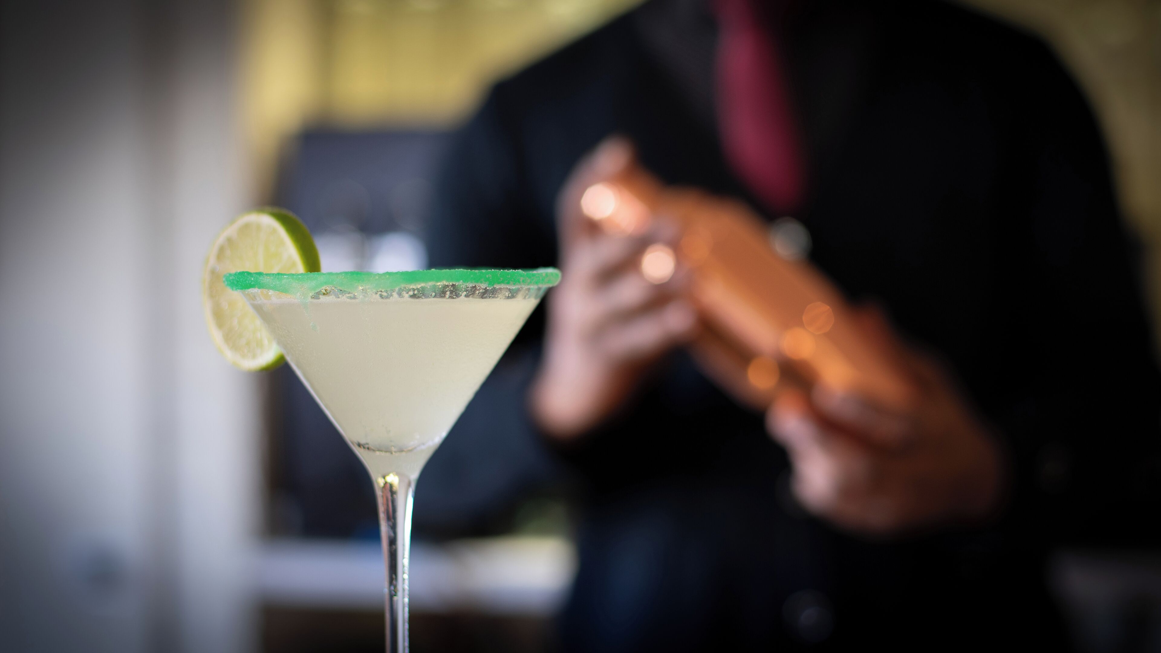 Un verre à martini garni d’une tranche de citron vert.