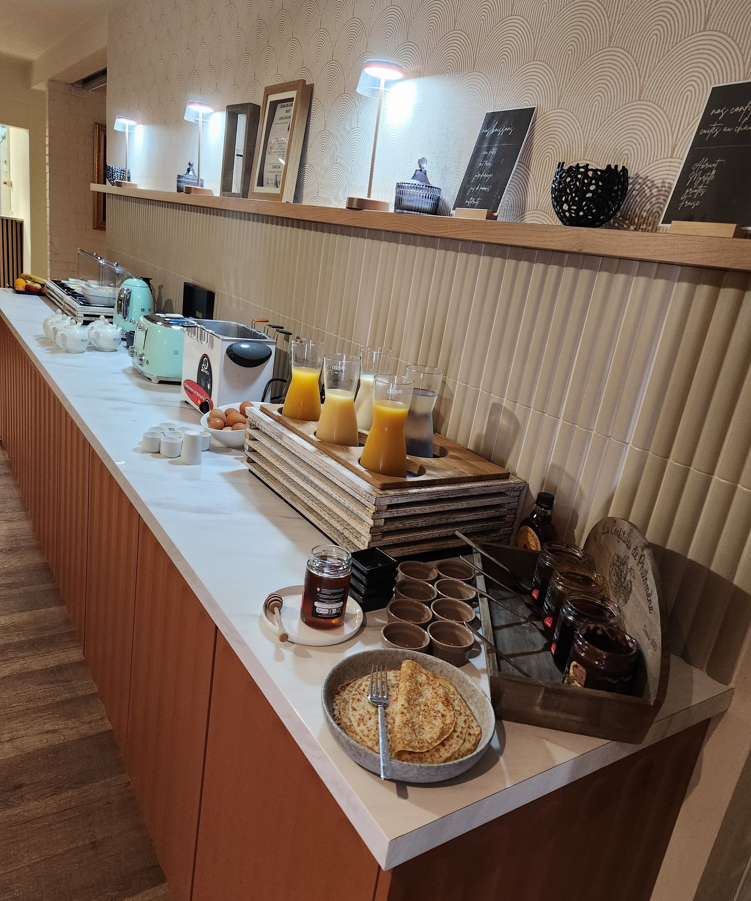 A breakfast buffet with various food items, beverages, and condiments.