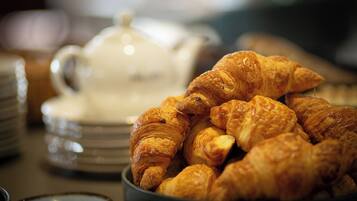 Una ciotola di croissant e un teiera su un tavolo.