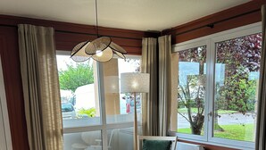 A modern living room with wooden flooring, a round coffee table, and two armchairs.